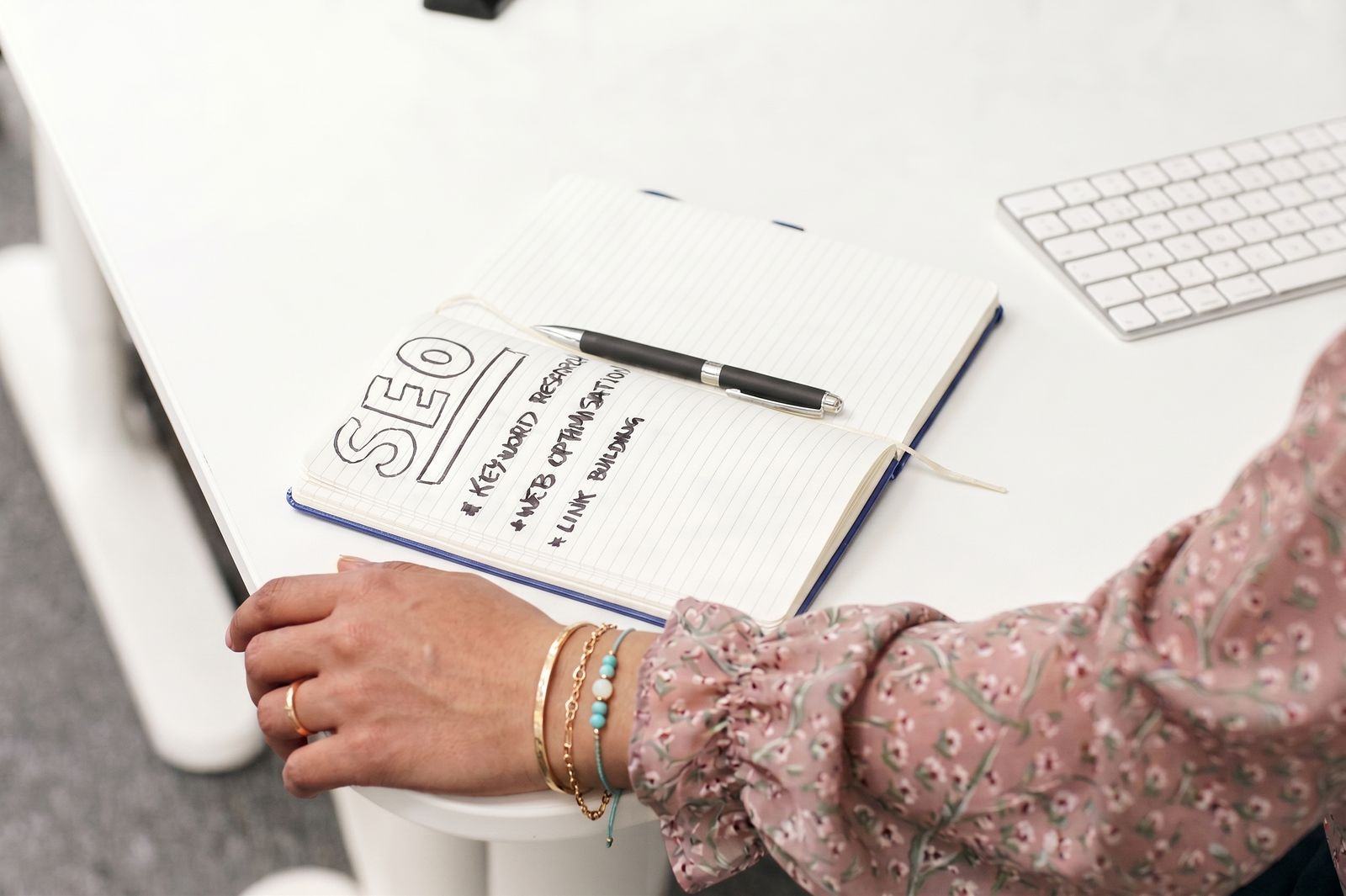 An open notebook headed “SEO”, listing keyword research, on-page optimisation and link building